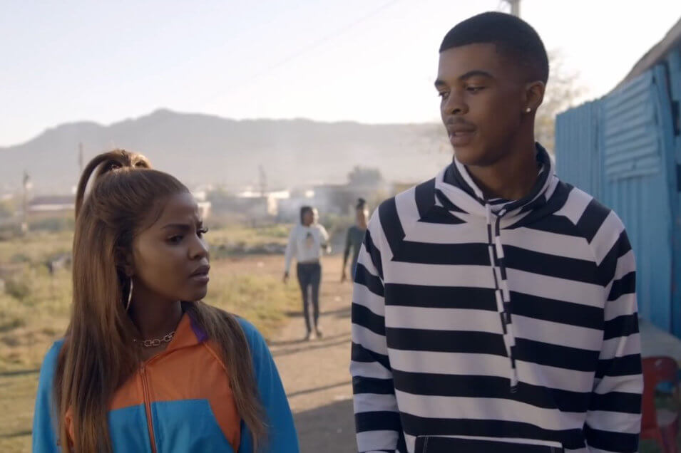 A young man and his girlfriend walking in a township